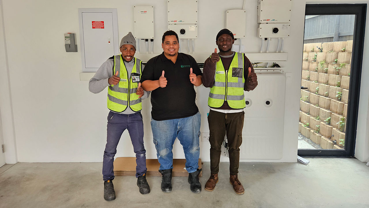 Treetops engineers standing in front of a SolarEdge installation